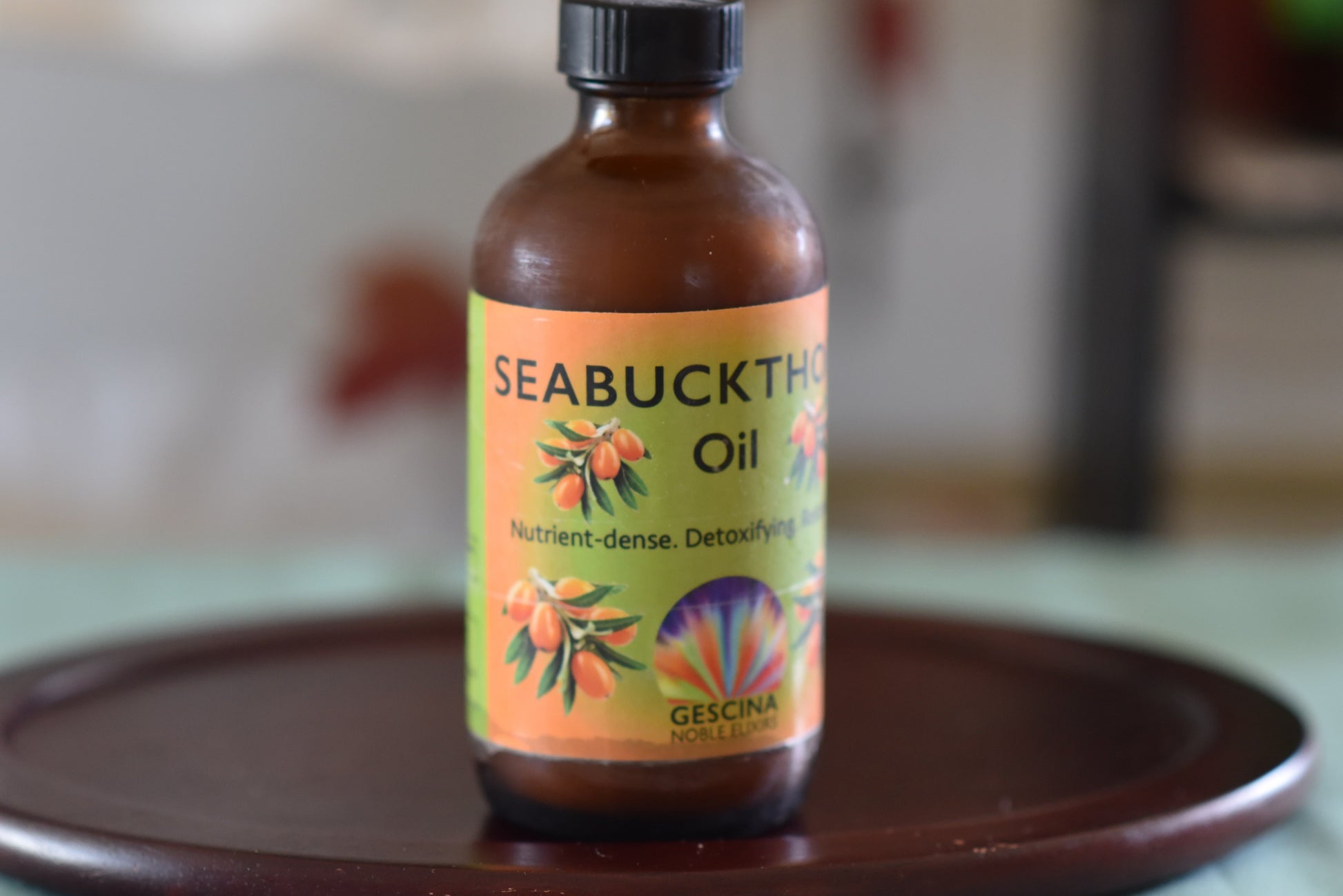 Bottle of Seabuckthorn oil on a wooden tray with a blurred background